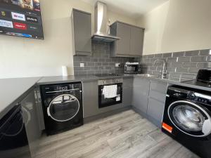 eine Küche mit einer Waschmaschine und einer Waschmaschine in der Unterkunft RYAN I AIR I BNB - 458 Mill Street - Free Parking in Liverpool