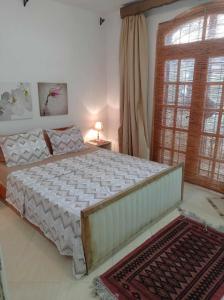 a bedroom with a large bed and a window at villa les oliviers in Port El Kantaoui