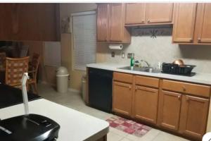 a kitchen with wooden cabinets and a sink at Taylors Furnished Home Comforts 3bd 1 & a half bath in Temple +13 photos