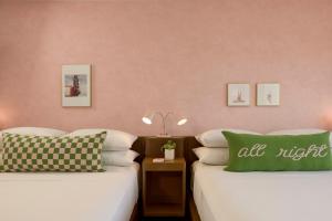 two beds in a room with pink walls at Downright Austin, A Renaissance Hotel in Austin