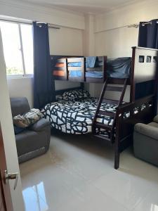 1 dormitorio con 2 literas y sofá en Apartamento en Vista Hermosa, Santo Domingo Este, en Cancino