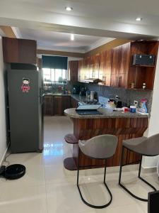 una cocina con nevera y algunas sillas. en Apartamento en Vista Hermosa, Santo Domingo Este, en Cancino