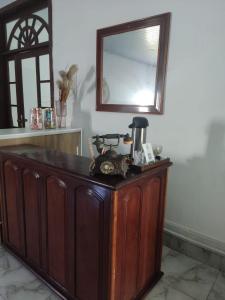 Un armario de madera en una habitación con espejo. en Eco Hotel Fischer LTDA, en Engenho Araci