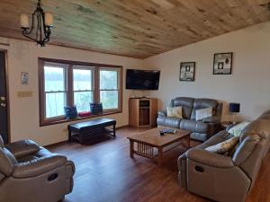 sala de estar con 2 sofás y TV en Kettle Moraine Lake House en Campbellsport