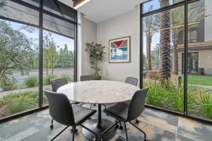 een eetkamer met een tafel en stoelen en grote ramen bij Luxury Modern Apt in Irvine in Santa Ana