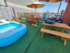 a backyard with a pool and tables and an umbrella at e-house第二ビル in Tokyo
