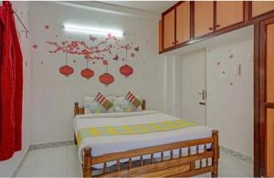 1 dormitorio con 1 cama con bolas rojas en la pared en Stay in serinity beach 2bhk villa., en Pondicherry
