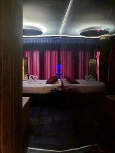2 camas en una habitación con cortinas rosas en Utopía Alicante - Adults Experience, en Alicante