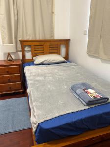 MJED House في Ingleburn: غرفة نوم عليها سرير وفوط
