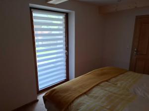 a bedroom with a large window with blinds at RELAX in Ebensee
