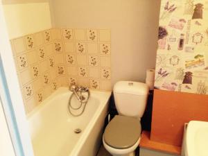 a bathroom with a toilet and a tub and a sink at Studio Plaisance in Contrexéville