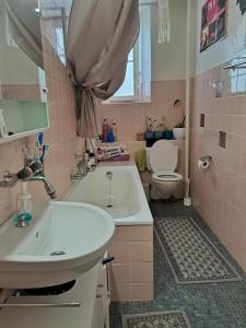 uma casa de banho rosa com um lavatório e um WC em À côté du lac em Vevey
