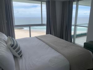 une chambre avec un lit avec vue sur la plage dans l'établissement Ocean Plaza Resort, à Gold Coast