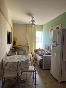 ein Wohnzimmer mit einem Tisch und einem Kühlschrank in der Unterkunft Apartamento Mobiliado com Área de Lazer in Caldas Novas