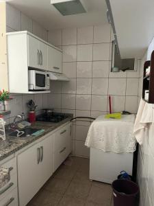 Apartamento Mobiliado com Área de Lazer في كالدس نوفاس: مطبخ صغير مع حوض وميكروويف