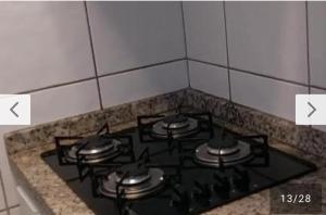 a stove top oven with four burners on it at Apartamento Mobiliado com Área de Lazer in Caldas Novas