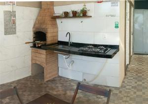 a kitchen with a stove and a brick oven at OLÍMPIA APARTS Kitnet com cozinha e banheiro privativo PISCINA AQUECIDA in Olímpia