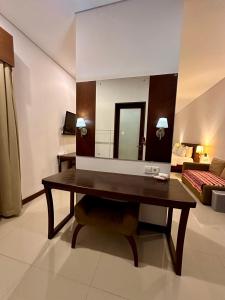 a desk in a room with a bed and a mirror at Karuna Uppala Villa Umalas in Canggu