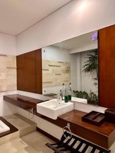 baño con lavabo y espejo grande en Karuna Uppala Villa Umalas en Canggu