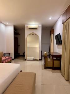 a hotel room with a bed and a table and a desk at Karuna Uppala Villa Umalas in Canggu