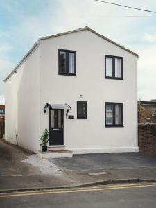uma casa branca com janelas pretas e uma porta em Rofennie Suite -Brand new luxury ensuite room! em Maidstone