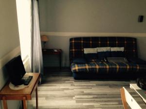 a living room with a couch and a table at Studio Plaisance in Contrexéville