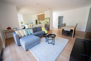 a living room with a blue couch and a table at Spacious & Modern 4 Bedrooms in Tuggeranong