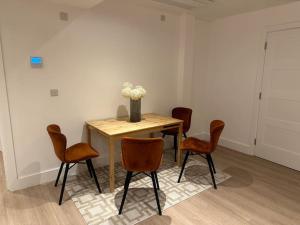 a table with four chairs and a vase of flowers on it at Beautiful and Spacious 2 bedroom in central london in London