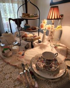 BellaireにあるApplesauce Inn Bed & Breakfastのテーブル(皿付)、ランプ、お茶セット