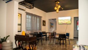 a room with tables and chairs and a piano at Hotelito Bonito Eli & Edw in Santo Domingo