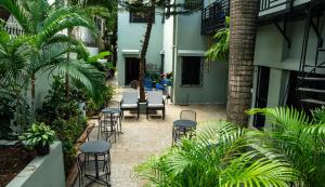 un patio con sillas y mesas en un edificio en Hotelito Bonito Eli & Edw en Santo Domingo