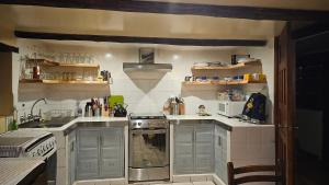 a kitchen with gray cabinets and a stove top oven at Charming house in Zuleta Mariano and Pastora in Zuleta