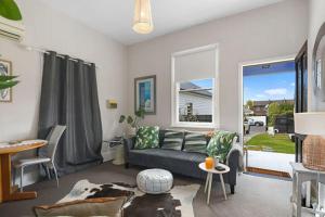 uma sala de estar com um sofá e uma janela em North Hobart cottage em Hobart