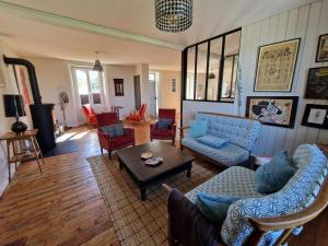a living room with couches and chairs and a table at Holiday Home Locquirec by Sandy Beach in Locquirec