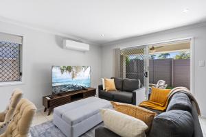 - un salon avec un canapé et une télévision dans l'établissement Tranquil Retreat Brisbane North, à North Lakes