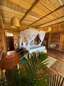 ein Schlafzimmer mit einem Bett in einem Holzzimmer in der Unterkunft Palaa Mayapo Ecolodge in Mayapo