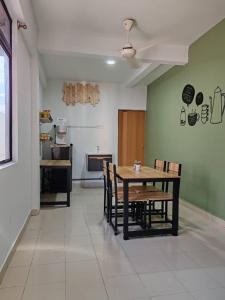 comedor con mesa y sillas y cocina en Suite Us Guesthouse Kubang Kerian, en Kota Bharu