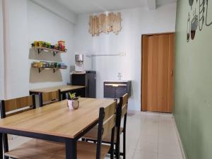a dining room with a wooden table and chairs at Suite Us Guesthouse Kubang Kerian in Kota Bharu