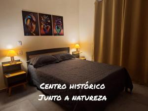 a bedroom with a bed and two lamps and a curtain at Suítes Recanto Petrópolis in Petrópolis