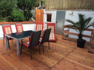eine Terrasse mit einem Tisch und Stühlen auf einer Holzterrasse in der Unterkunft Ferienwohnung Sandkaute in Hellstein