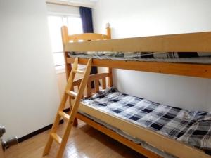 Etagenbett in einem Zimmer mit einer Leiter in der Unterkunft Ueda Building - Vacation STAY 8560 in Asahikawa