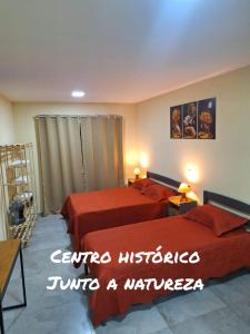 una habitación de hotel con dos camas y las palabras centro negligencia convertir un almacén en Suítes Recanto Petrópolis en Petrópolis