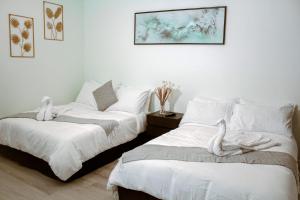 1 dormitorio con 2 camas con sábanas blancas y una foto en Departamento céntrico, amplio y nuevo cerca del aeropuerto y foro sol, en Ciudad de México