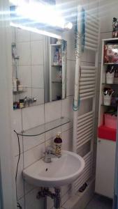 y baño con lavabo y espejo. en Great cozy city apartment self check in, en Hannover