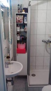 y baño pequeño con lavabo y ducha. en Great cozy city apartment self check in, en Hannover