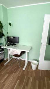 escritorio con ordenador y silla en una habitación en Great cozy city apartment self check in, en Hannover