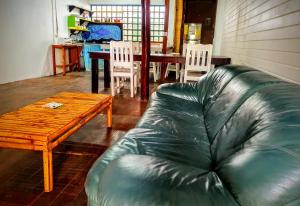sala de estar con sofá de cuero y mesa de madera en Arana House, en Puerto Viejo