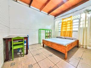 a bedroom with a bed and a desk and a table at Arana House in Puerto Viejo
