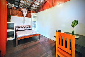 a bedroom with a bed and a table and a chair at Arana House in Puerto Viejo