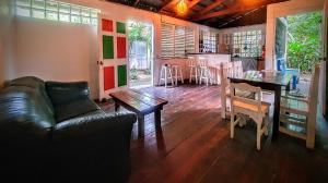 a living room with a leather couch and a table at Arana House in Puerto Viejo